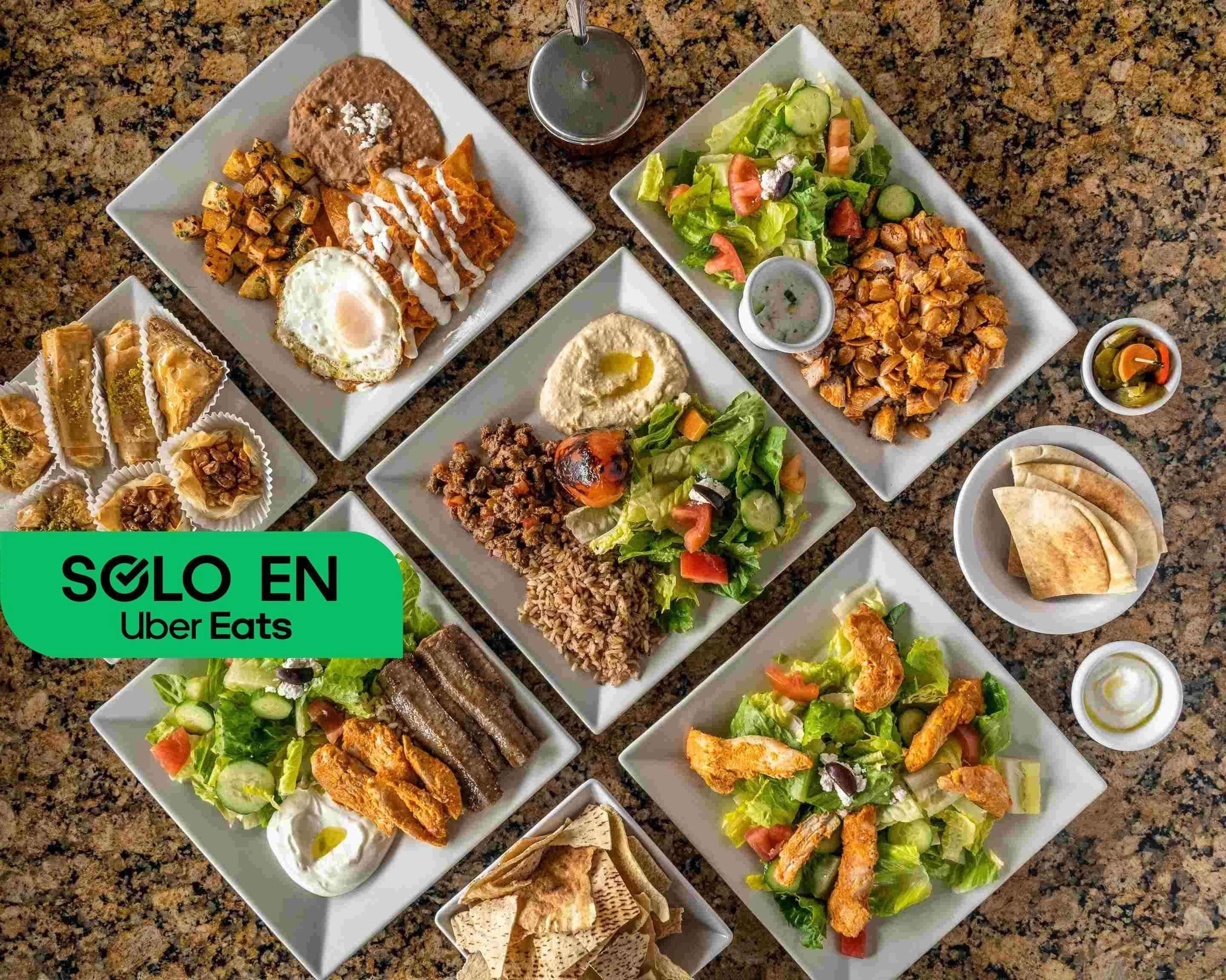 Mesa con ensaladas, hummus, pan pita y platos de inspiración libanesa