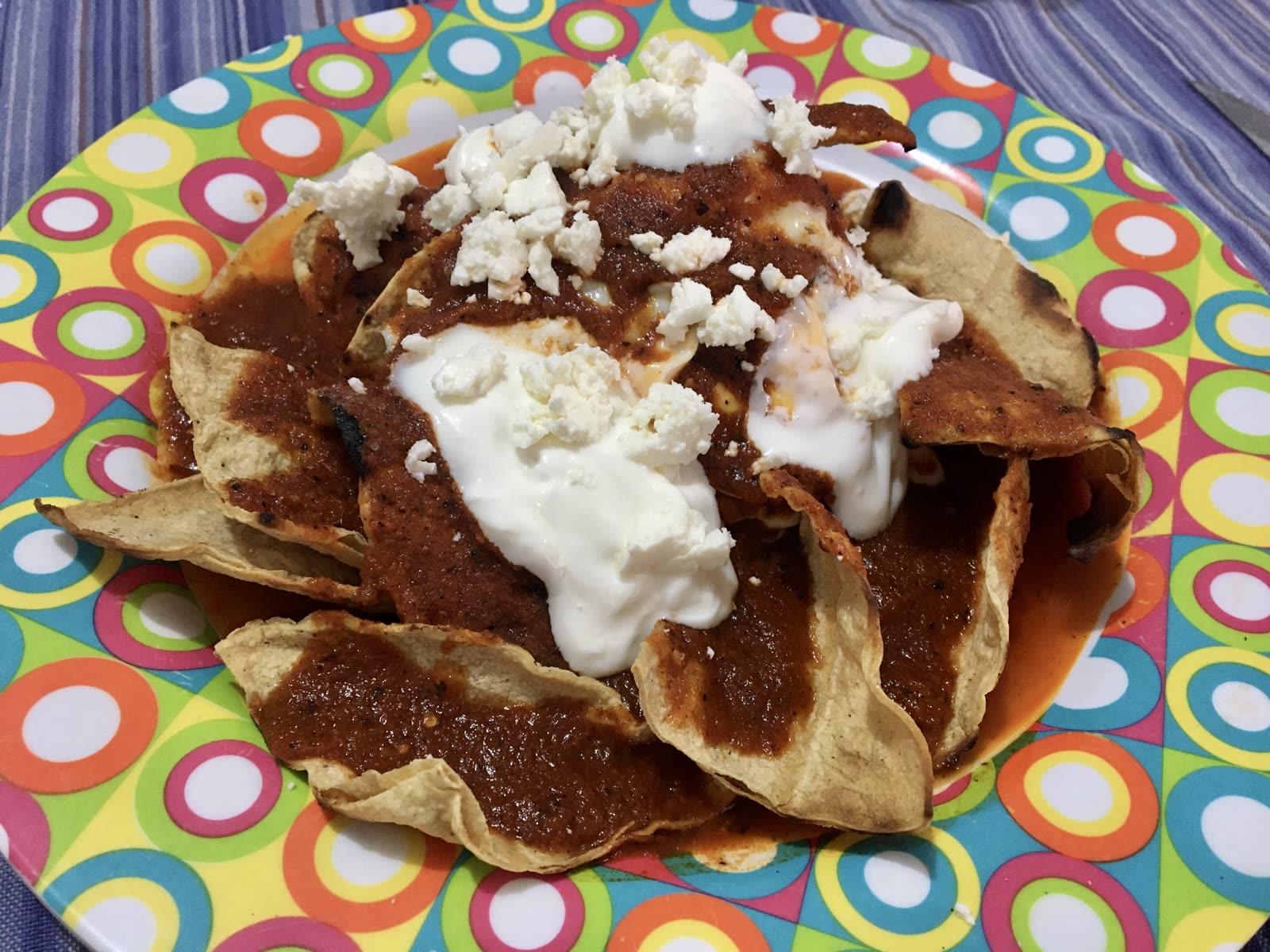Chilaquiles con salsa roja, crema y queso