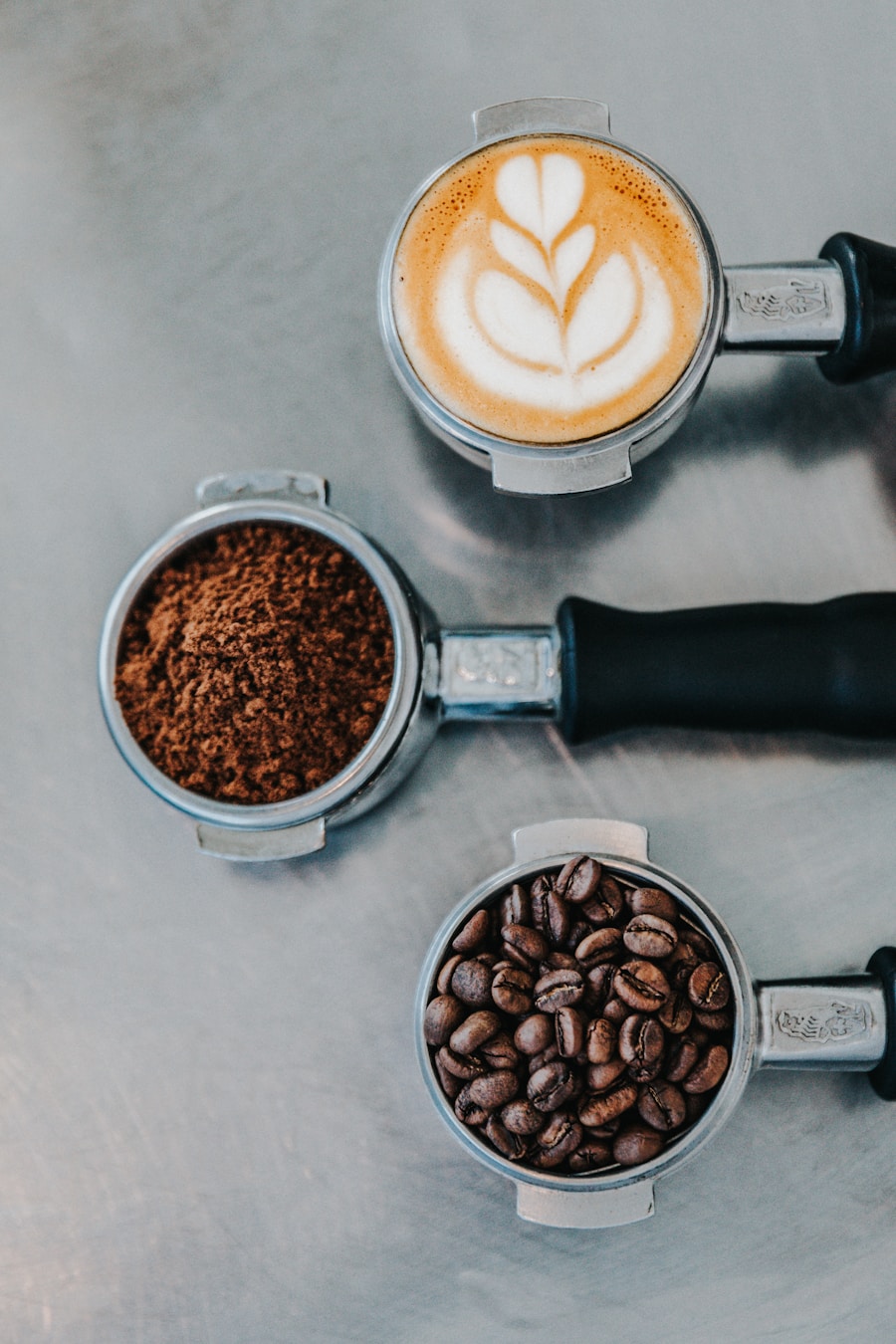 Café con arte de leche, café molido y granos sobre una mesa de preparación
