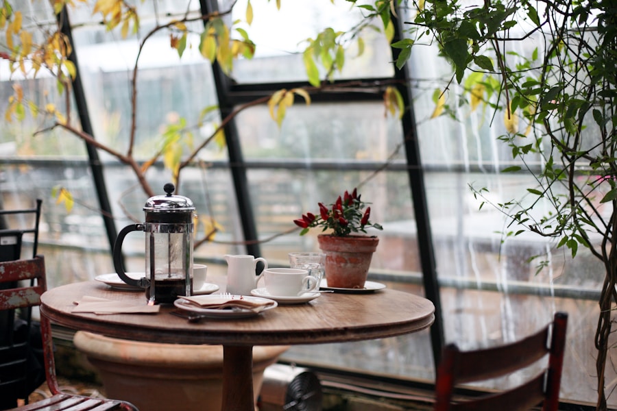 Mesa de café rodeada de plantas junto a ventanales