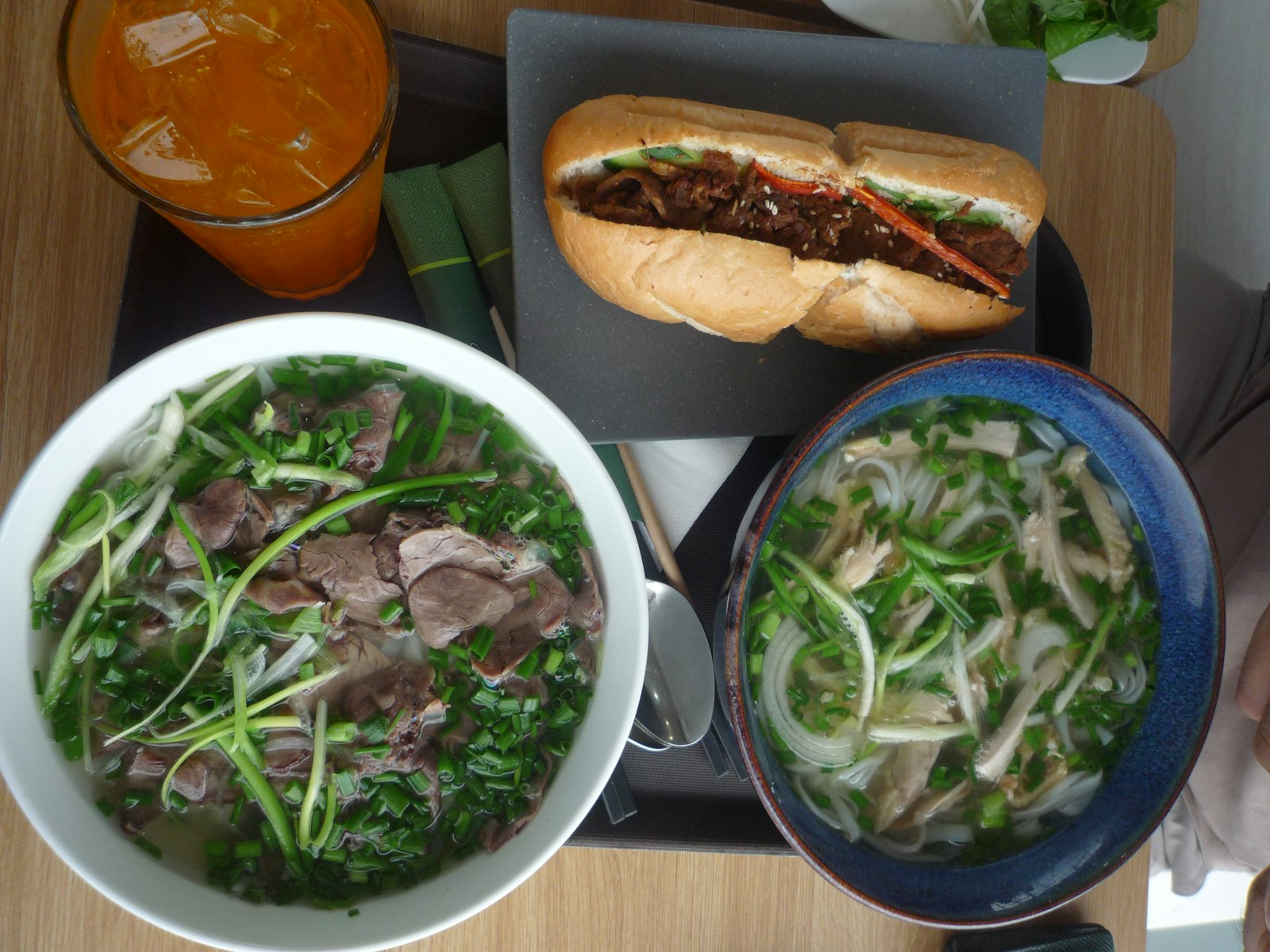 Imagen de referencia de una mesa con pho y banh mi; no es una foto de Pequeño Saigón